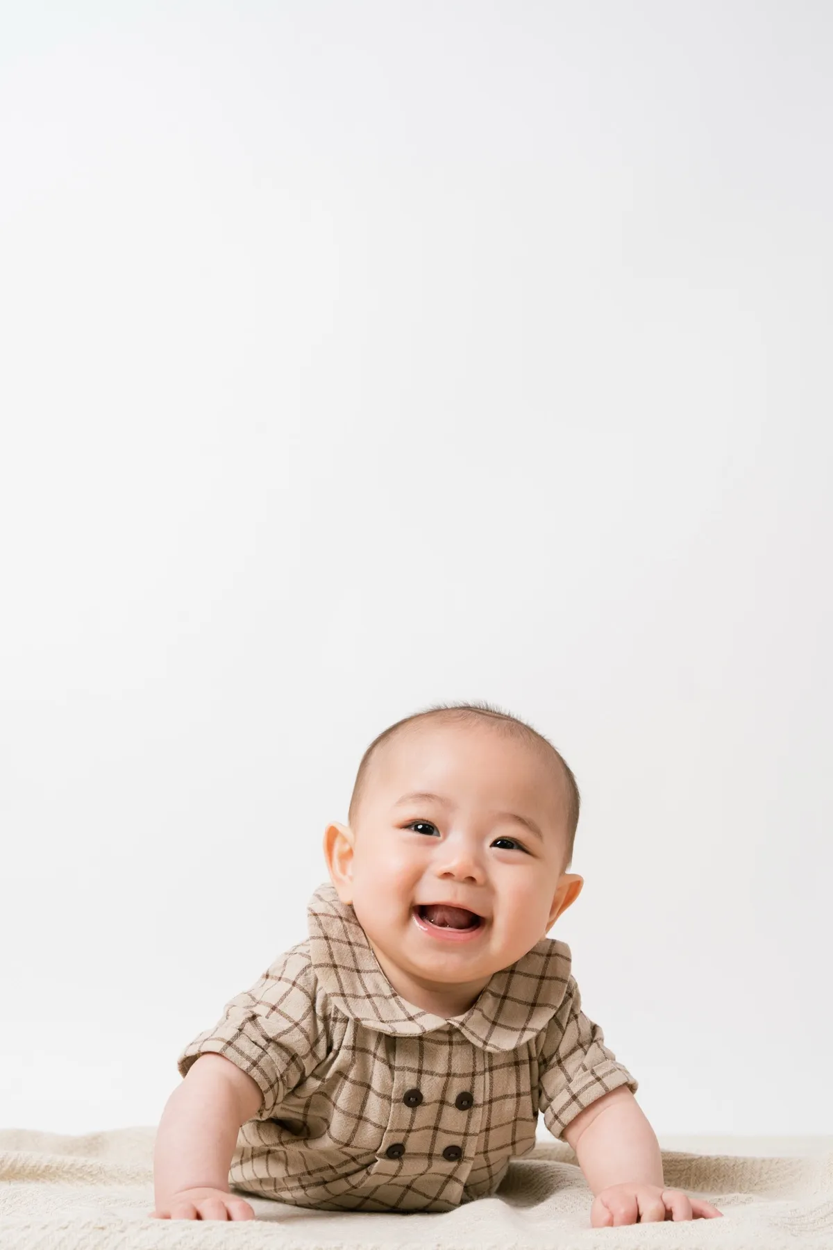 白背景をハイハイしながら笑う赤ちゃん